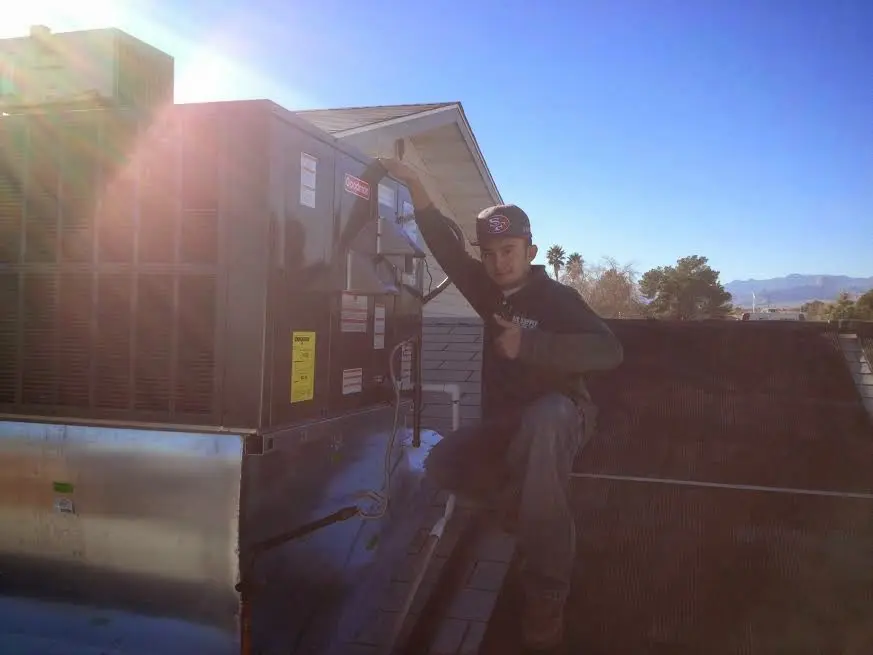 HVAC technician performing Air Duct Repair on a rooftop unit in Wright City